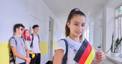 Student teenager girl with the flag of Germany inside school, school